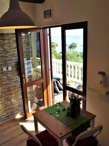 einen Tisch und Stühle in einem Zimmer mit Balkon in der Unterkunft Apartment Maslina in Premuda