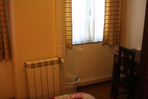 Zimmer mit einem Heizkörper und einem Fenster in der Unterkunft Duas Nações Guest House in Porto