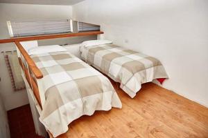 two beds in a room with wooden floors at Borgo S.Maria Di Vulci in Montalto di Castro +36 photos