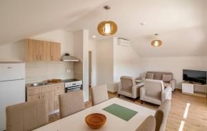 a kitchen and living room with a table and chairs at Apartmani Luka Meljine in Meljine