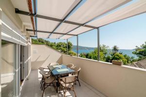 a patio with a table and chairs on a balcony at Apartmani Luka Meljine in Meljine