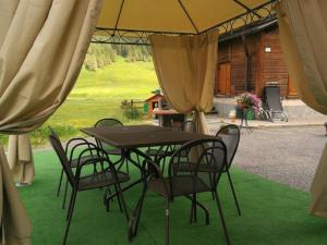 a table and chairs under an umbrella on the grass at Al Molino in Livigno