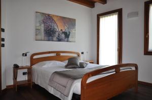 sypialnia z drewnianym łóżkiem i dużym oknem w obiekcie Agriturismo Ancillotto w mieście Meolo +30 zdjęć