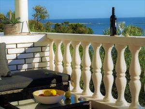 a white railing with a bowl of fruit and a bottle of wine at Apartment Maslina in Premuda