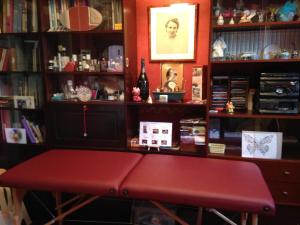 a room with a red bench in front of a book shelf at Chambre chez l'habitant sur petite place in Reims