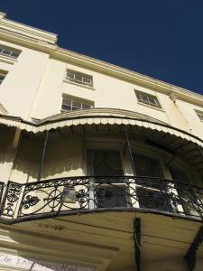 a white building with a balcony on the front of it at Regency Hotel in Brighton & Hove