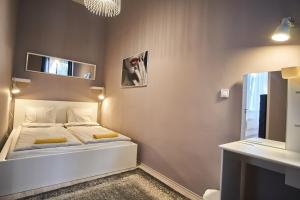 ブダペストにあるDesign Apartment in the City Center with ACの小さなベッドルーム(ベッド1台、鏡付)