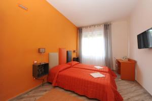 a bedroom with a red bed and a window at B&B Ariston Pisa Tower in Pisa