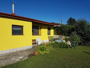 ein gelbes Haus mit einem Hof davor in der Unterkunft Ferienhaus Sonnenweg in Sankt Andrä bei Frauenkirchen