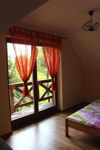 a bedroom with a bed and a large window at Zawoja Chaty Górskie D3 in Zawoja