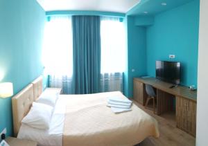 アルハンゲリスクにあるSerafima Hotelのベッドルーム1室(ベッド1台、デスク、テレビ付)