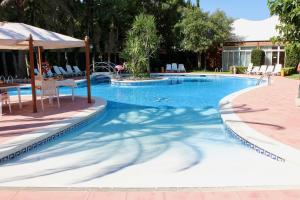 a large swimming pool with a table and chairs at Ampuria Inn in Empuriabrava