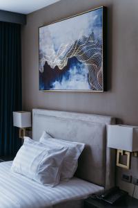 1 cama en una habitación de hotel con un cuadro en la pared en PVL Suites, en Dumaguete