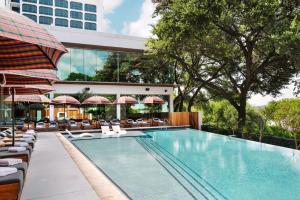 a swimming pool with lounge chairs and a hotel at The LINE Austin in Austin