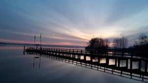 a dock on a body of water at sunset at Yachthafenblick in Bad Zwischenahn