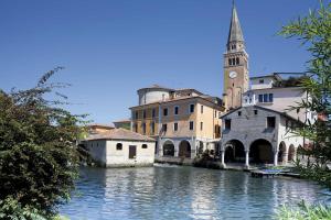 a group of buildings and a church and a river at Atelier in Portogruaro