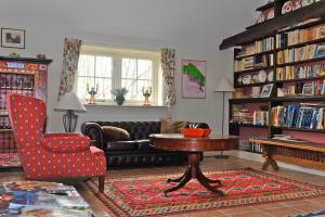 a living room with a couch and a table and a chair at Bed & Breakfast de Neust in Beesd