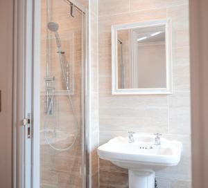 a bathroom with a shower, sink, and mirror at Swan Hotel in Arundel