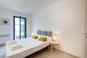 ジローナにあるFlateli Pou Rodó 1の白いベッドルーム(大型ベッド1台、窓付)