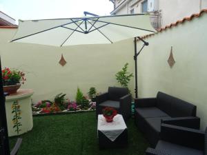 a patio with two chairs and an umbrella at B&B Alòs in Sapri
