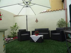 a patio with chairs and a table with an umbrella at B&B Alòs in Sapri