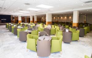 ein Raum mit grünen und grauen Stühlen und Tischen in der Unterkunft Hotel Madeira Centro in Benidorm + 137 Fotos