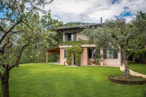 a house with a green lawn in front of it at B&B Al Sentiero in Caprino Veronese