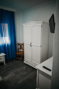 un armario blanco en una habitación con silla en Hotel Nuro, en Barbate