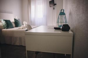 a room with a bed, a dresser and a window at Hotel Nuro in Barbate