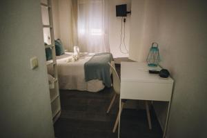 a bedroom with a bed and a desk at Hotel Nuro in Barbate