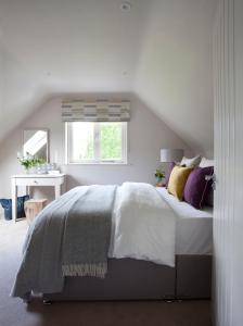 a white bedroom with a bed and a window at The Elements Lodge in Pettigoe