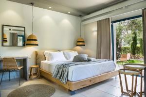 a bedroom with a bed and a table and chairs at Avithos Resort Hotel in Svoronata