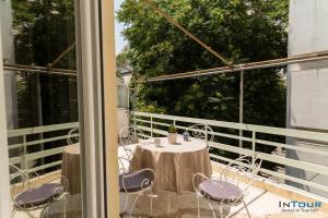 um pátio com uma mesa e cadeiras numa varanda em Art point under Acropolis em Atenas