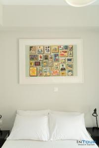 a picture hanging above a bed with a white pillow at Art point under Acropolis in Athens