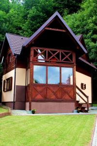 a barn with a large wooden door in a yard at Zawoja Chaty Górskie D5 in Zawoja