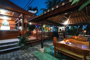 a restaurant with a deck with a table and benches at D and B Bungalow's by DeWizZ Management in Nusa Lembongan