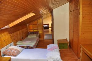 a small room with two beds in a wooden room at Hotel Palota in Budapest