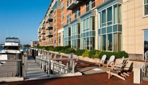 a row of chairs sitting on a dock next to a building at Battery Wharf Hotel, Boston Waterfront in Boston