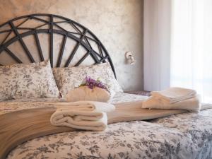 1 dormitorio con 1 cama con toallas en La Brigata Apartments Orange House, en Cavallino-Treporti