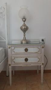 a white dresser with a lamp on top of it at Estate Dafnopanagia Luxury Apartment Ourania in Kariá