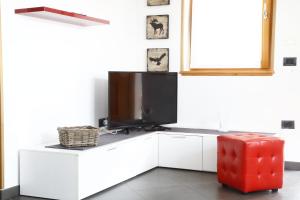 a living room with a tv on a white cabinet at Adamello Brenta Sunshine in Madonna di Campiglio