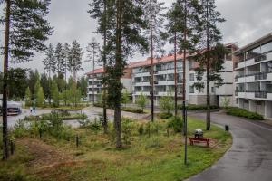 an apartment building in a park with trees at Vierumäki Chalets 4414 in Vierumäki