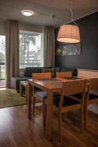 ヴィエルマキにあるVierumäki Chalets 4414のリビングルーム(テーブル、椅子、ソファ付)