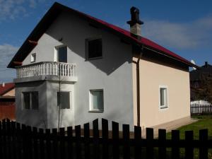 a white house with a red roof behind a fence at Komforna kuca Pale in Pale
