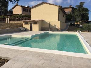 a swimming pool in front of a house at Agriturismo Villalta in Ponte Felcino