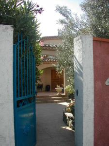 an entrance to a building with a blue gate at les alicantes in Coursan
