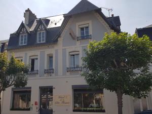 een wit gebouw met een zwart dak bij Hôtel de la Côte Fleurie in Deauville