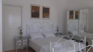 KariáにあるEstate Dafnopanagia Luxury Apartment Ouraniaの白いベッドルーム(ベッド1台、鏡付)