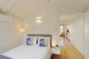 ポルトにあるHM - Flores Skylightのベッドルーム1室(青と白の枕が備わるベッド1台付)