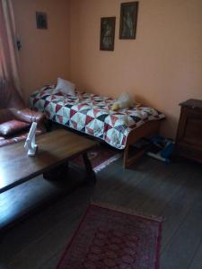 Gastzimmer für Übernachtung Гостевая комната في Oberbipp: غرفة نوم بسرير وطاولة واريكة
